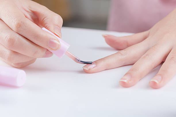 Applying nail polish to fingernails during a manicure session